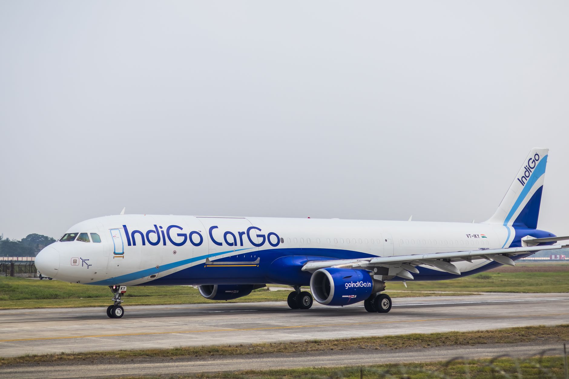 Side view of an IndiGo Cargo airplane on an airport runway during daytime.