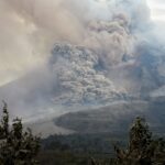 A powerful eruption of Mount Sinabung in North Sumatra, Indonesia, showcasing volcanic smoke and ash clouds.