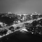 Black and white aerial view of Indore cityscape at night, showcasing urban streets and buildings.