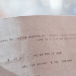 Close-up of typewritten Cyrillic text on vintage paper with a blurred background.