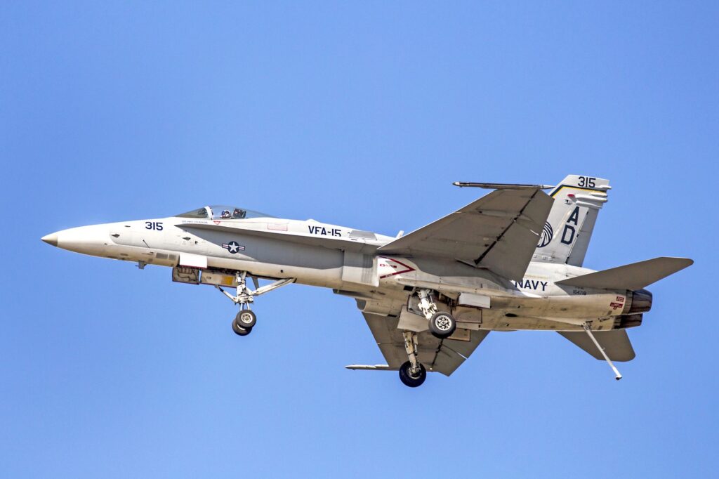 F/A-18C Hornet jet of the US Navy with landing gear deployed, flying over Florida.