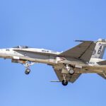 F/A-18C Hornet jet of the US Navy with landing gear deployed, flying over Florida.