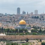 Captivating aerial view of the Dome of the Rock with Jerusalem's skyline in the background.