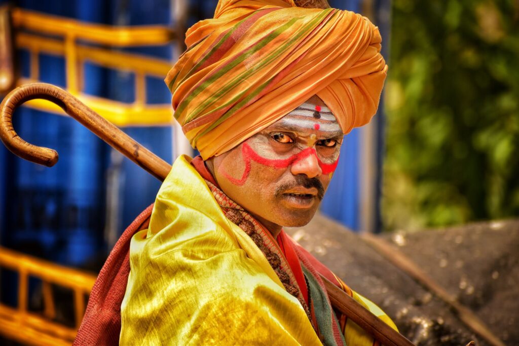 Traditional Indian man with painted face and turban, vibrant cultural expression.