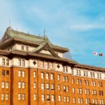 Historic government building facade in Nagoya showcasing imperial crown style architecture under a bright blue sky.
