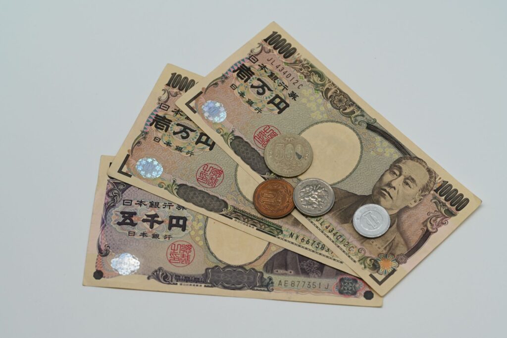 Close-up of Japanese Yen banknotes and coins arranged on a flat surface.