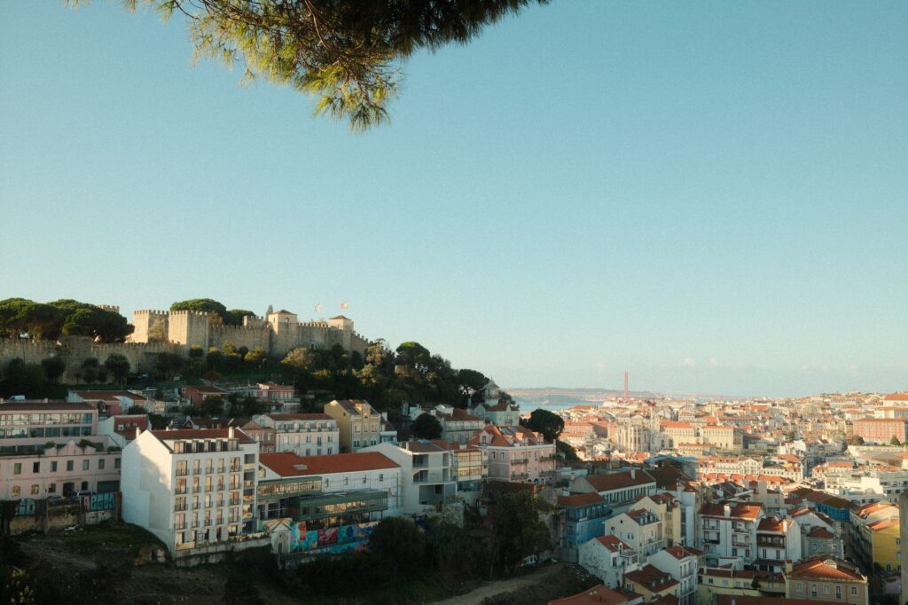 Explore the stunning cityscape of Lisbon featuring the iconic São Jorge Castle during a clear day.