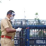 A police officer in Kerala, India, equipped with safety gear, focuses on public security.