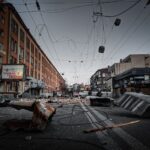 A city street in Kyiv is left in ruins, showcasing debris and destruction in an urban environment.