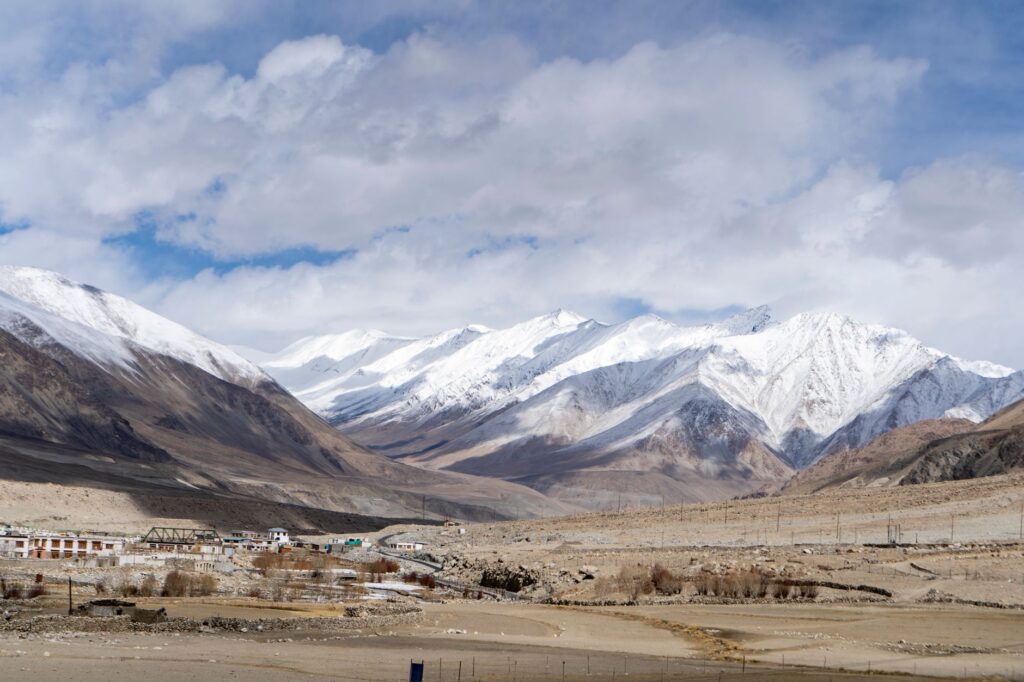 Captivating landscape of snow-covered peaks in India under a cloudy sky.