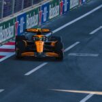 A Formula 1 racing car speeding along the Baku City Circuit during a race event.