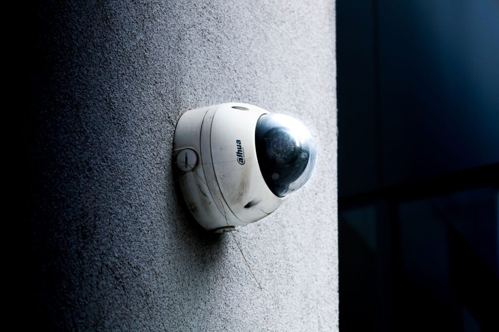 Close-up view of a dome security camera mounted on a concrete wall for surveillance.