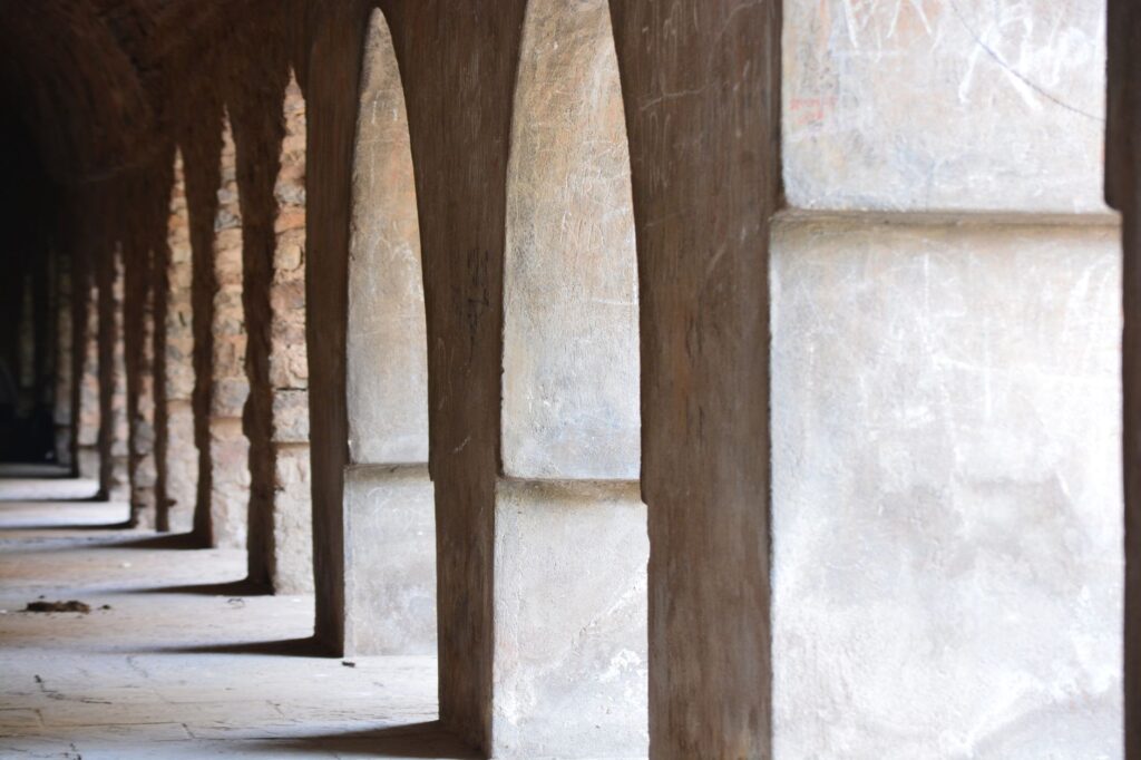 A row of ancient stone arches in a historic Delhi fort, showcasing rich architectural heritage.