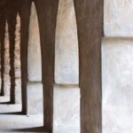 A row of ancient stone arches in a historic Delhi fort, showcasing rich architectural heritage.