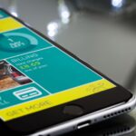 Close-up of a smartphone displaying a billing app interface on a reflective surface.