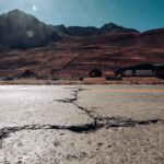 Cracked road leading to the Andes mountains in Mendoza, Argentina, under a clear sky.