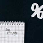 A notebook with 'tax planning' written on a grid paper next to a percent symbol on a black background.