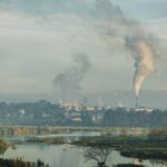 A factory emitting smoke over a natural landscape in Kon Tum, Vietnam.