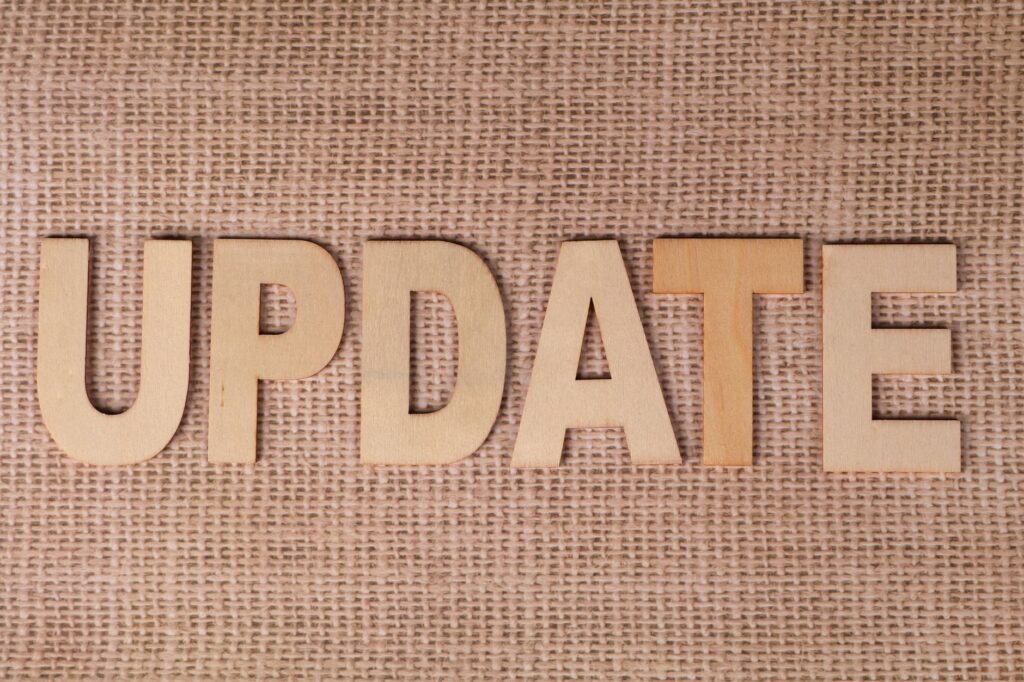Wooden letters arranged to spell 'UPDATE' on a textured burlap surface, perfect for business or project imagery.