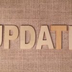 Wooden letters arranged to spell 'UPDATE' on a textured burlap surface, perfect for business or project imagery.