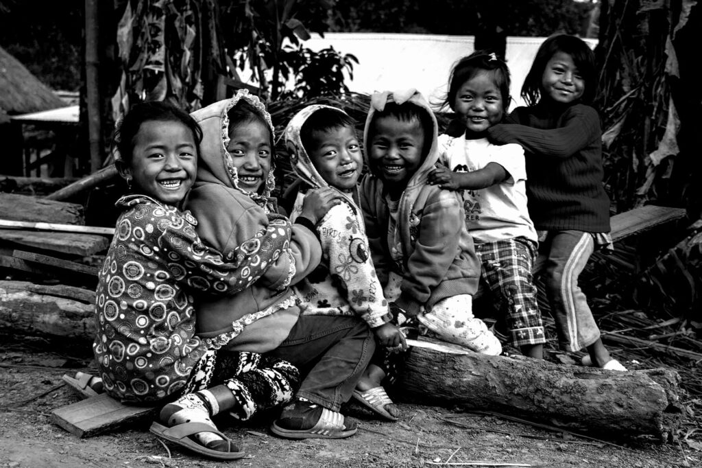 Group of smiling children playing outdoors in rural Noney, showcasing happiness and carefree childhood.