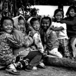 Group of smiling children playing outdoors in rural Noney, showcasing happiness and carefree childhood.