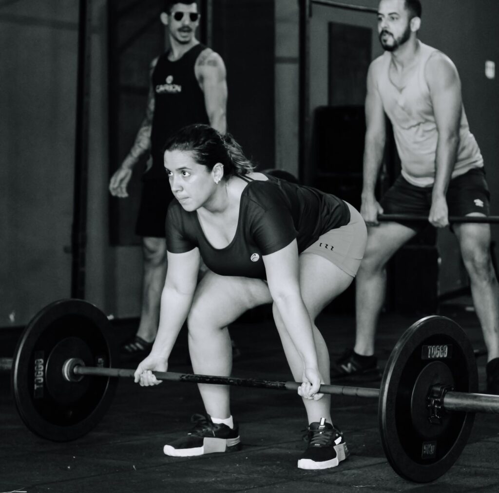 Woman lifting weights with determination during a workout session indoors. Fitness training and strength building.
