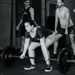 Woman lifting weights with determination during a workout session indoors. Fitness training and strength building.