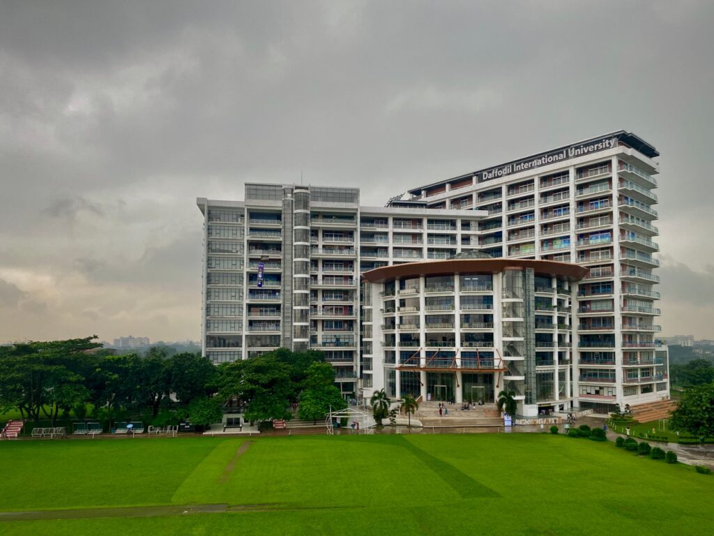 Modern architectural view of Daffodil International University with lush green surroundings in Dhaka.