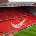 Aerial view of Anfield Stadium's iconic red seats and pitch, showcasing its architecture and design.