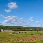 A picturesque view of Pennsylvania farmland under a clear blue sky with rolling hills.