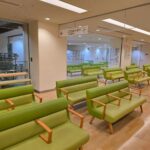 Empty hospital waiting area with green seats in Shibuya, Tokyo.