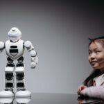 Young Asian girl interacts with a high-tech toy robot, showcasing innovation and curiosity.
