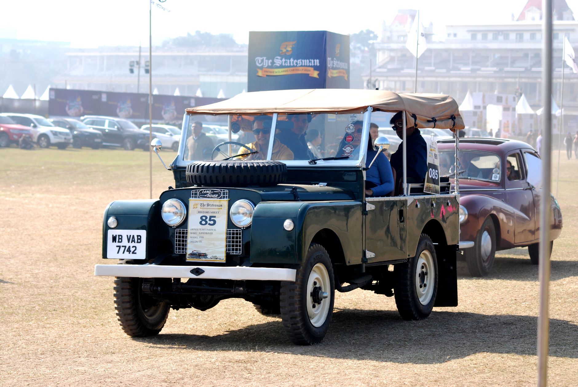 A classic Land Rover at a vintage car rally, showcasing automotive history outdoors.