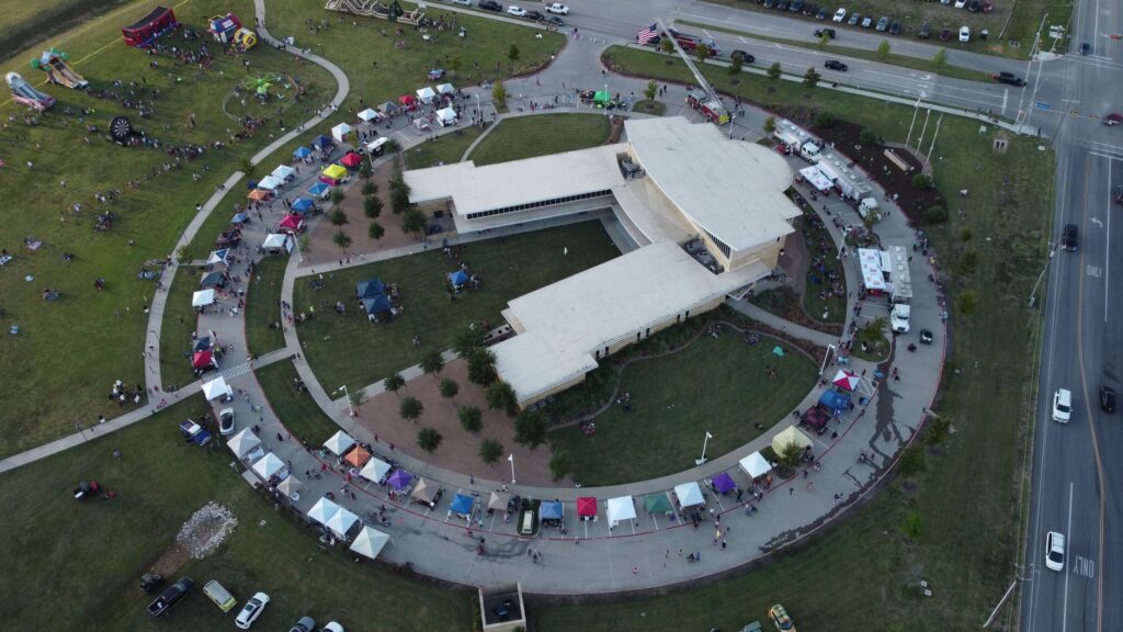 Aerial view of a circular building surrounded by festival tents in Royse City, TX.