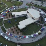Aerial view of a circular building surrounded by festival tents in Royse City, TX.