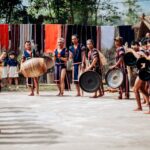 A vibrant cultural scene depicting a traditional gong performance in Kon Tum, Vietnam.