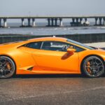A striking orange Lamborghini Huracan parked by the iconic Bandra-Worli Sea Link in Mumbai, India.