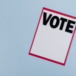 Minimalist vote card on a blue background, symbolizing election and democracy.