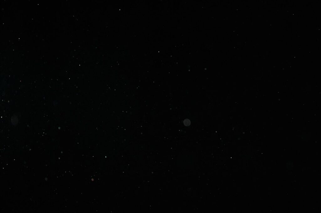 Creative abstract image of particles on a black background resembling a starry night sky.