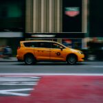 Dynamic shot of a yellow taxi speeding through a New York City street.