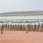 A large group of uniformed individuals standing in formation outdoors, illustrating discipline and unity.
