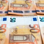 Detailed image of multiple 50 Euro bills stacked, showcasing currency design.