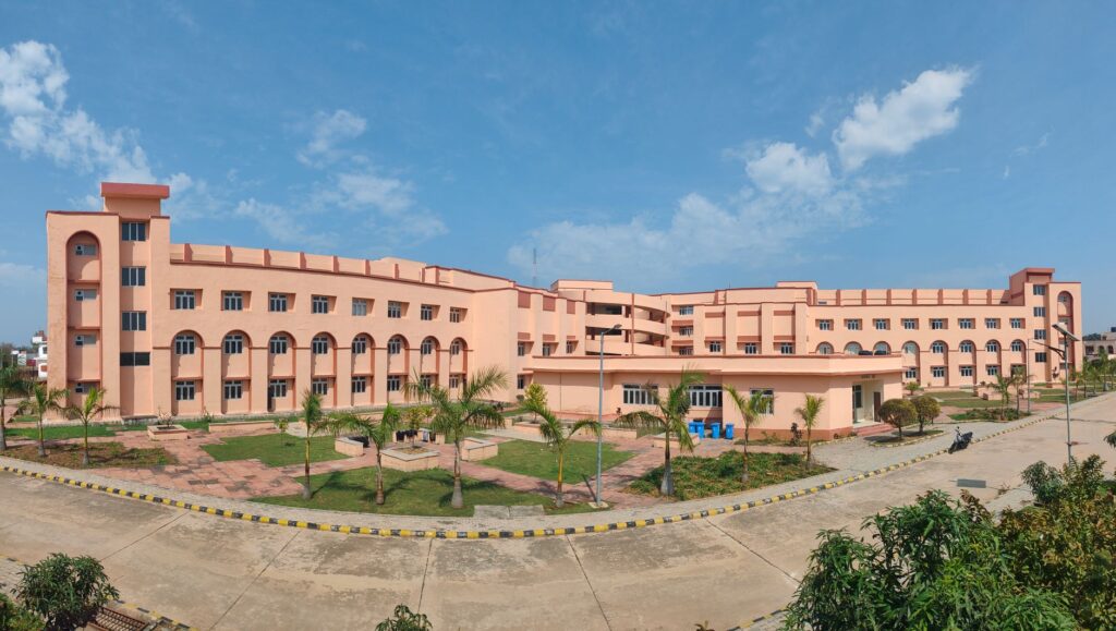 Large educational building with clear blue sky and landscaped grounds.