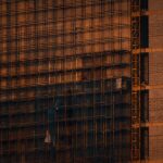 Scaffolding and incomplete building structure at sunset in Noida, India.