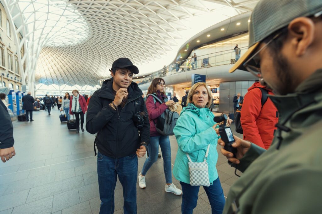 A bustling scene inside a modern train station with travelers and distinctive architectural design.