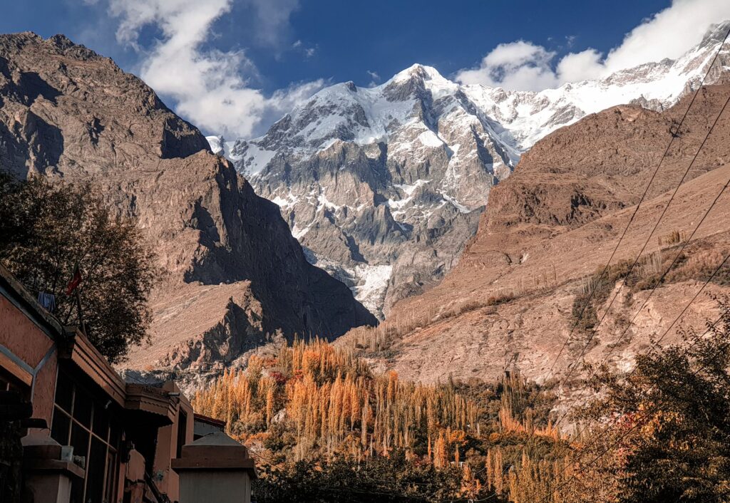 Stunning view of rugged mountains with autumn foliage under a clear blue sky.
