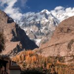 Stunning view of rugged mountains with autumn foliage under a clear blue sky.