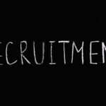 Chalk-written 'RECRUITMENT' on a black chalkboard, ideal for HR and hiring themes.