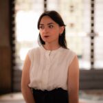 Portrait of an elegant young woman posing indoors with soft lighting in Milan, Italy.